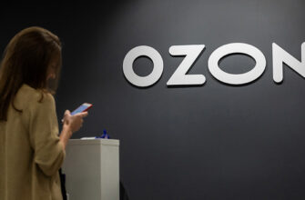Девушка смотрит в телефон на фоне логотипа компании